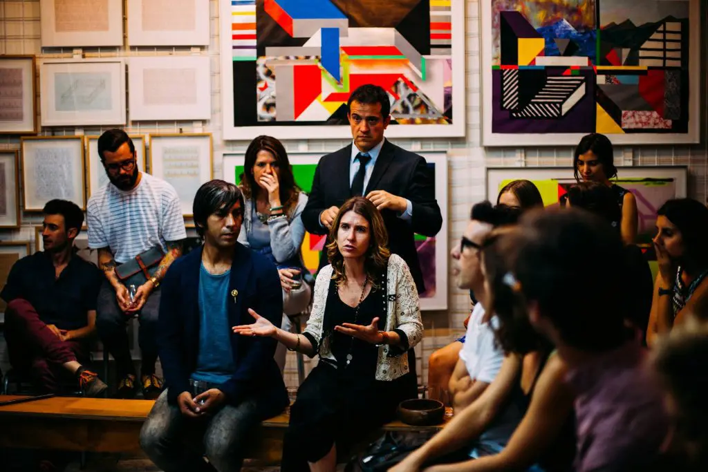 Grupo de personas reunidas en un espacio creativo, dialogando y compartiendo ideas, representando colaboración y trabajo en equipo.