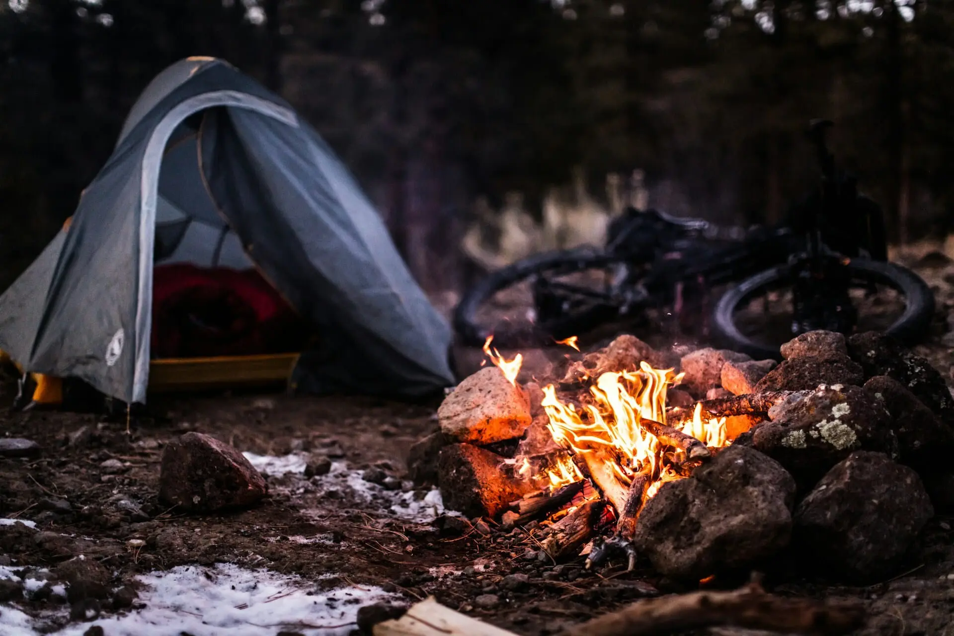 una hoguera al lado de una tienda de camping